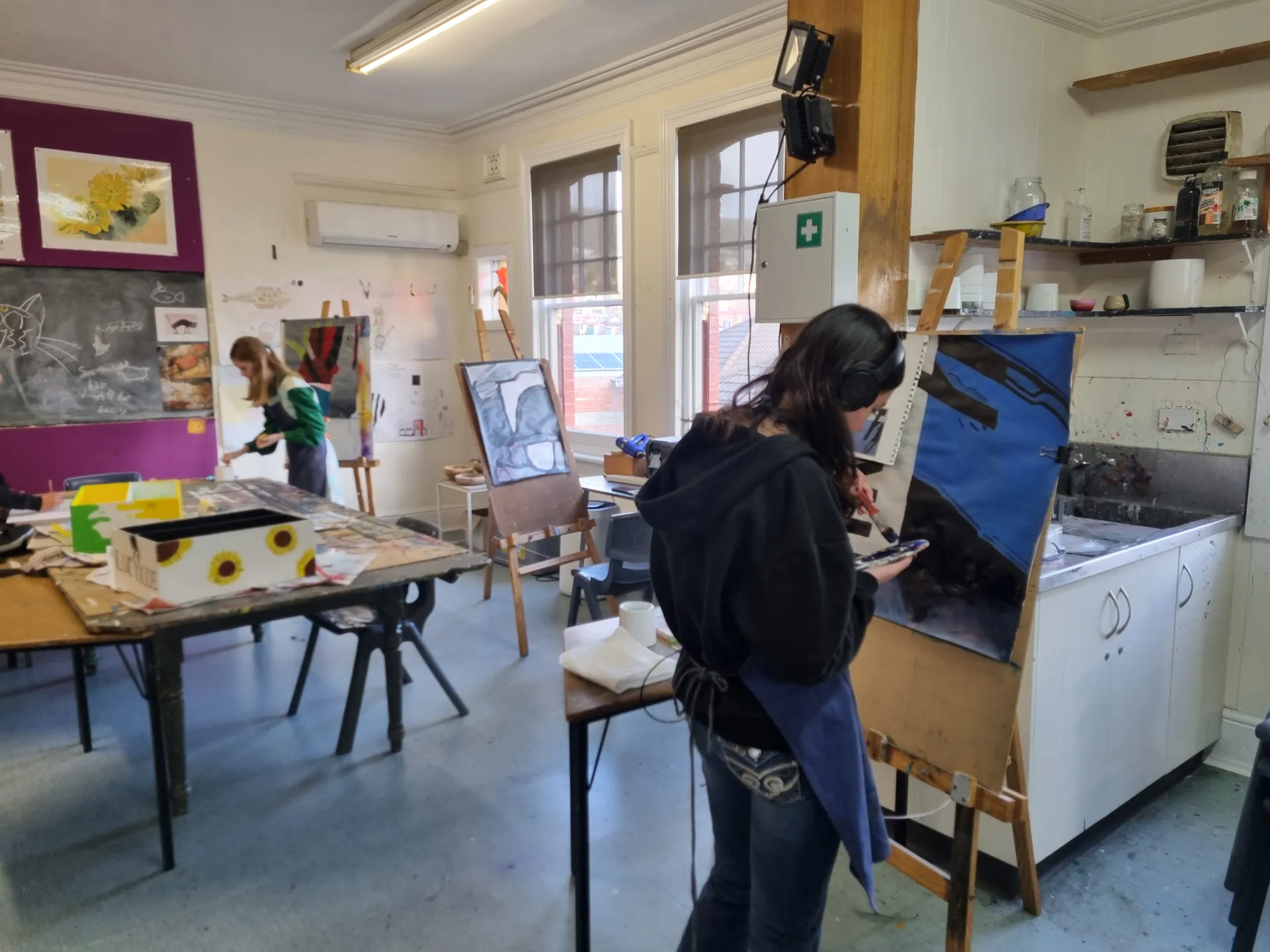 Student painting at an easel in the art studio